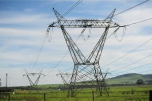 Power lines with blue skies and green lanscape