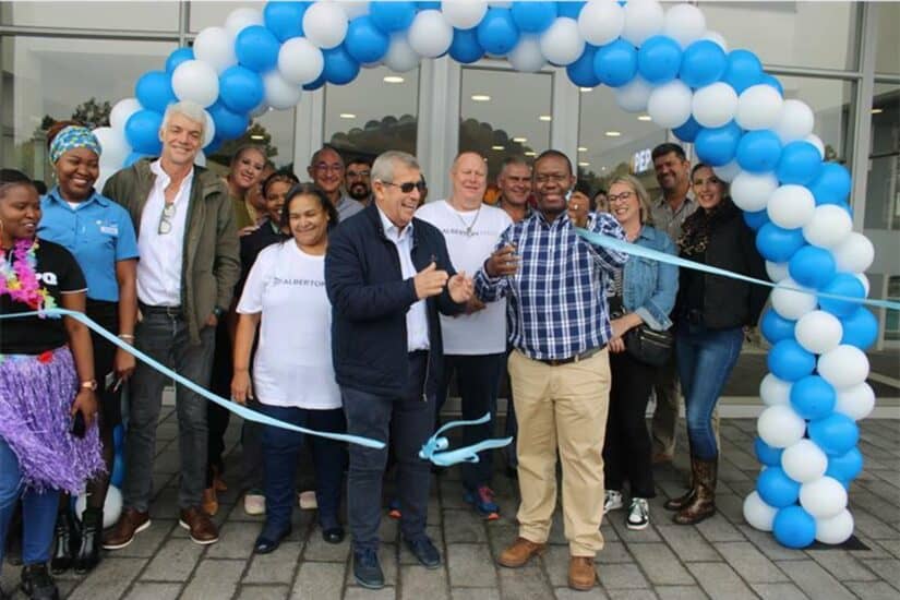 Ribbon cutting ceremony with blue and white balloons.