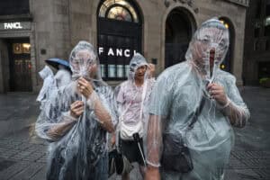 People protect themselves with disposable rain ponchos