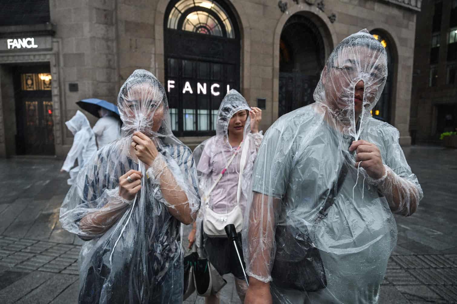 People protect themselves with disposable rain ponchos