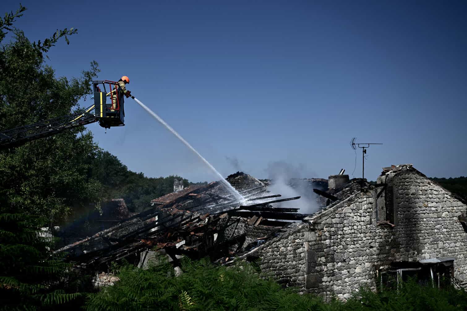 A firefighter works at the site of a French holiday cottage