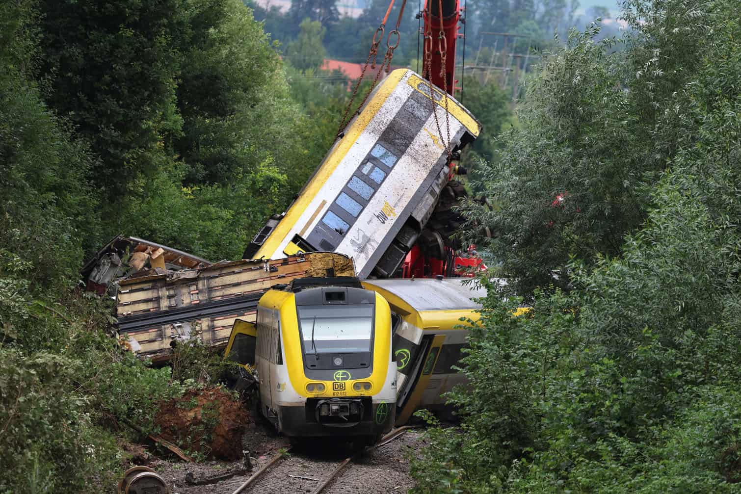 A crane lifts a damaged railway wagon