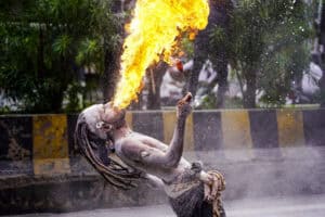 A reveller performs a fire-breathing stunt