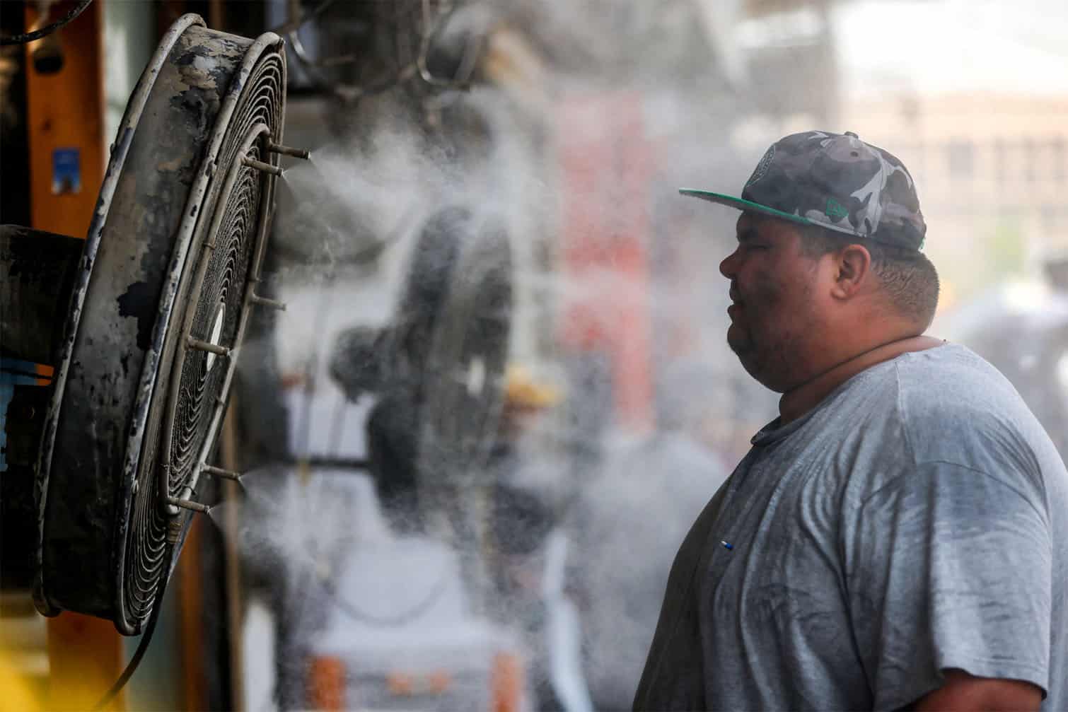 A man stands before one of the 'water spray fans'