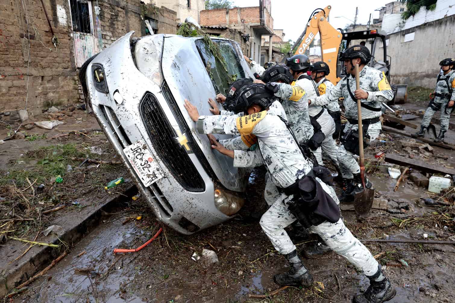 Army soldiers turn over a damaged car