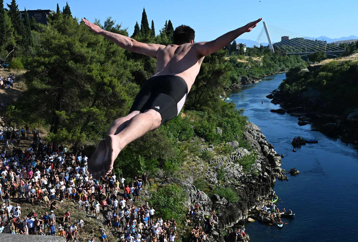 Spectators watch as a high diver takes flight