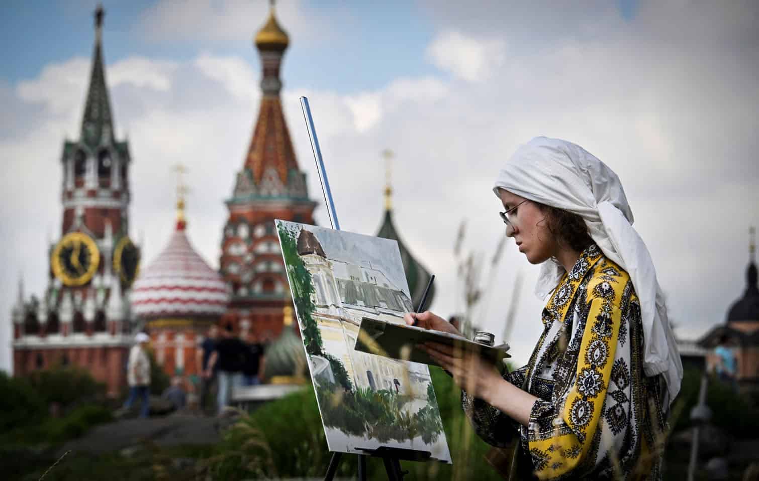 A girl paints in front of the Kremlin's Spasskaya tower