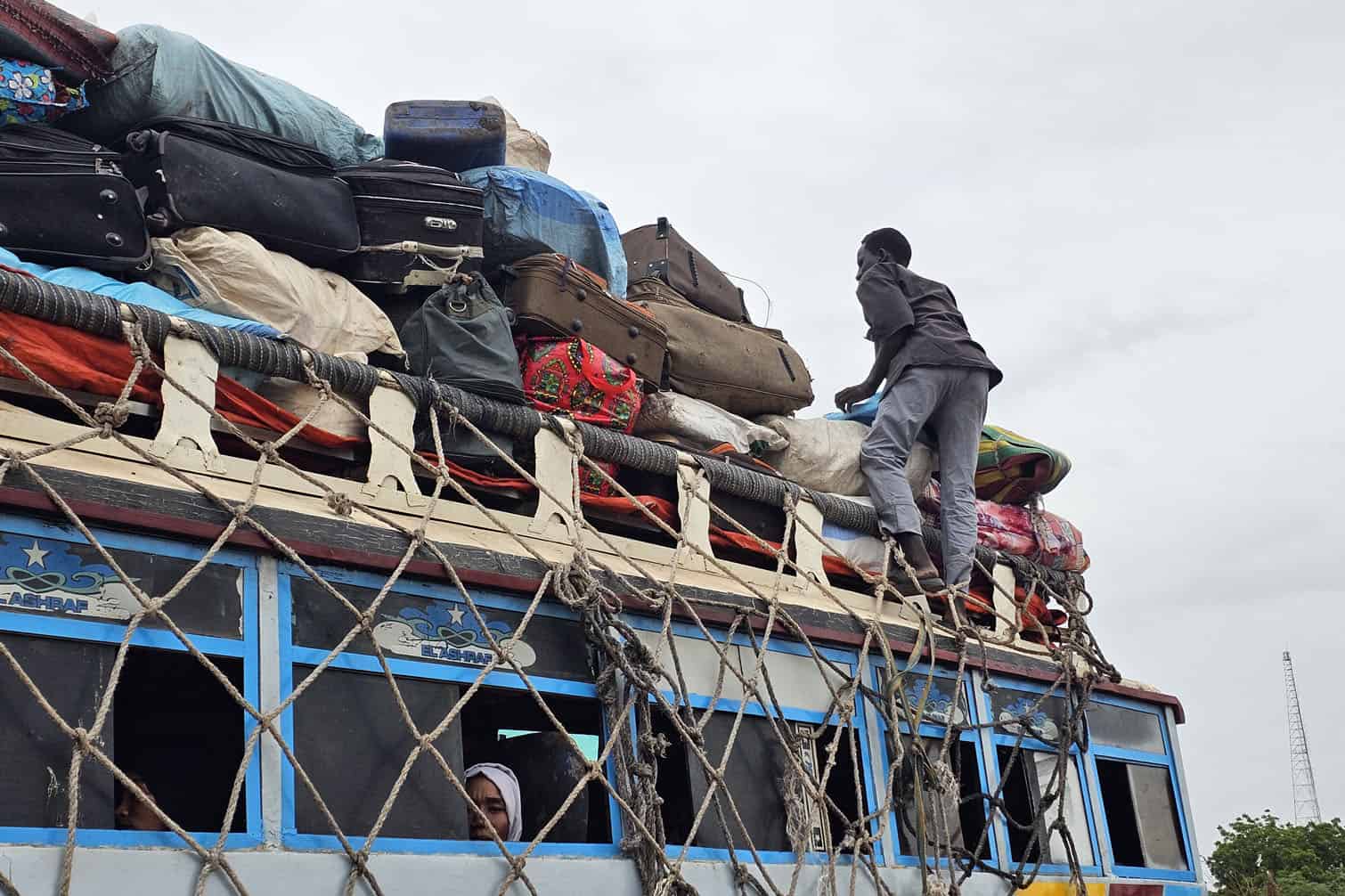 Displaced Sudanese arrive at a bus stop