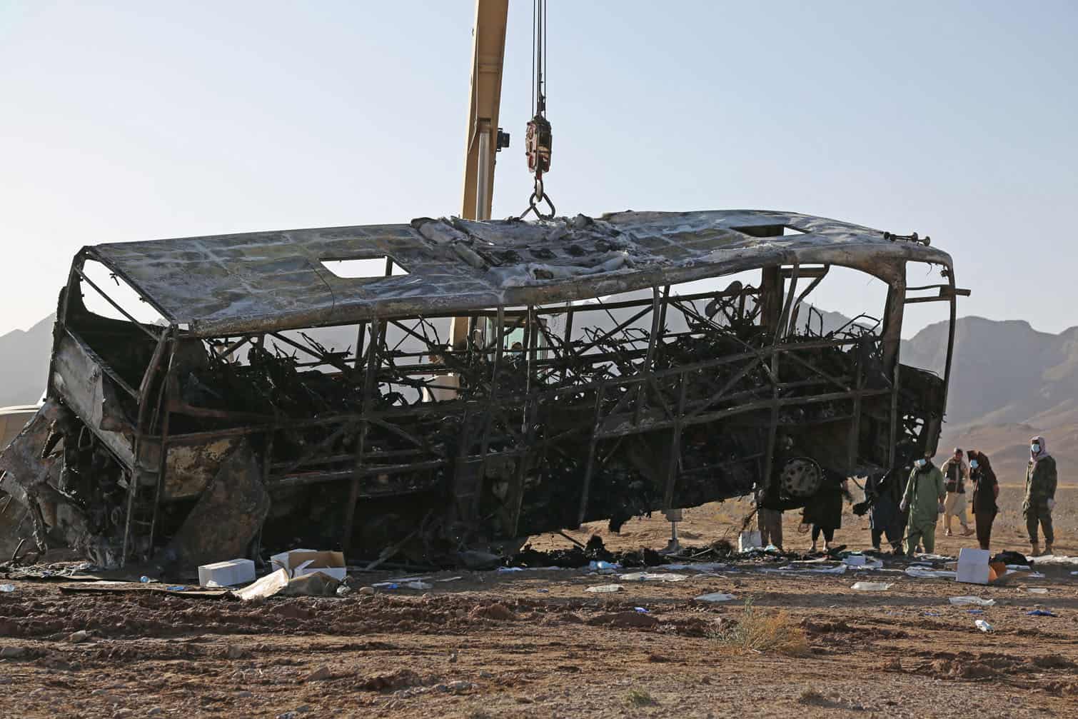The wreckage of a bus is towed at the site of a crash