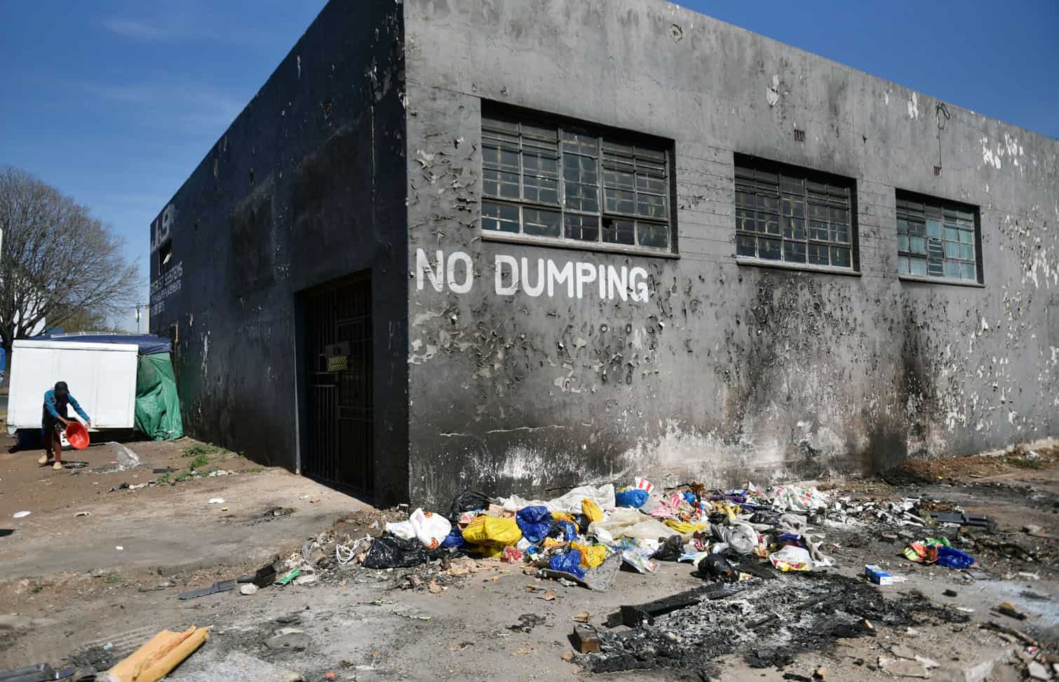 People dump next to a sign written 'No Dumping'