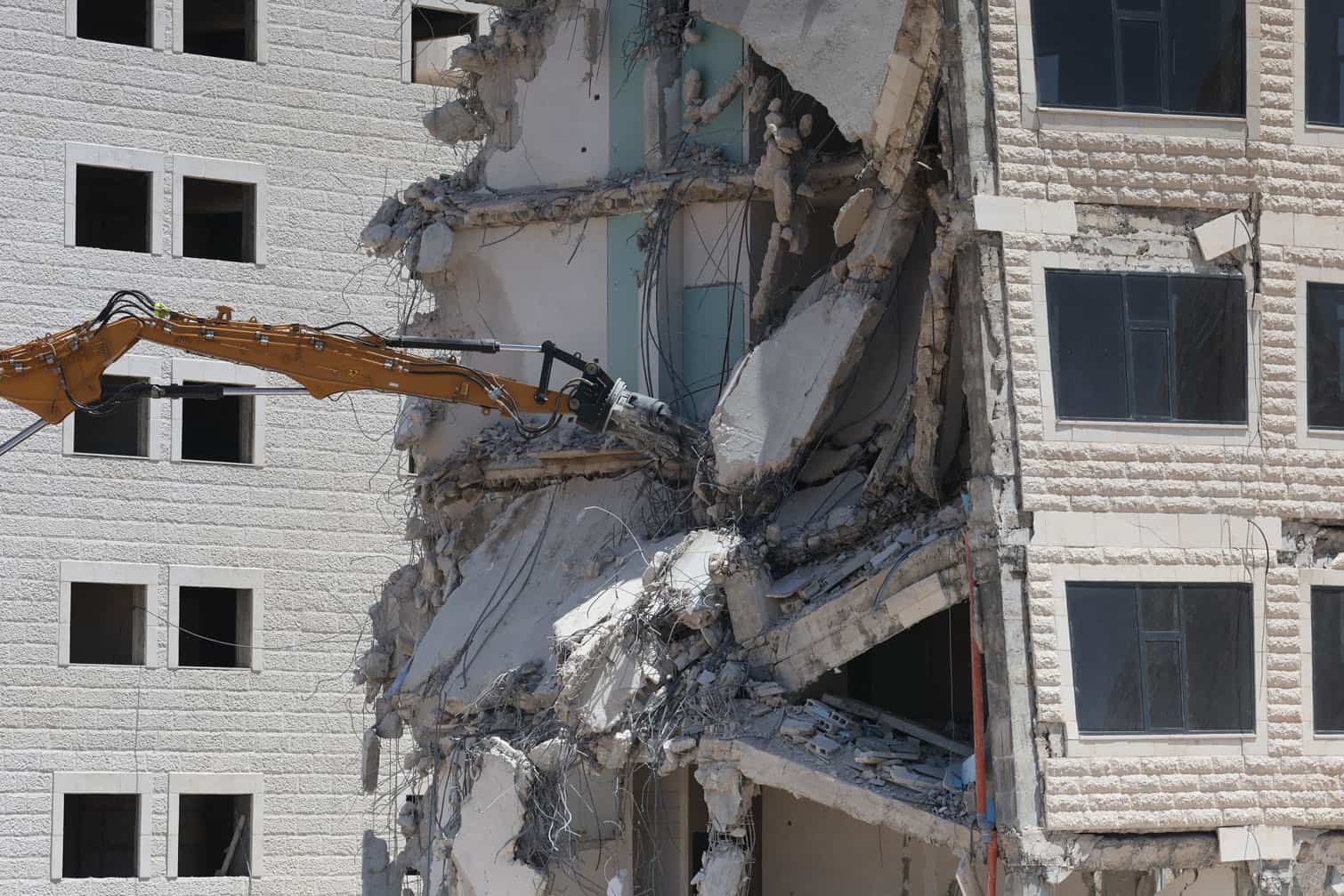 An Israeli excavator tears down a building