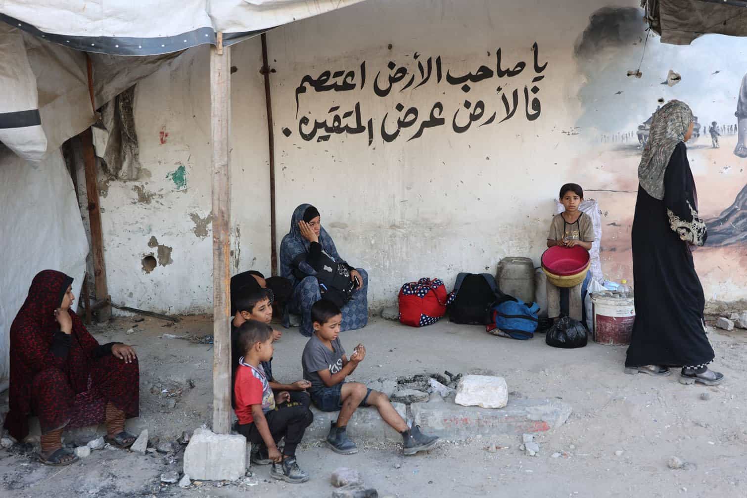 Palestinians rest on the side of a road