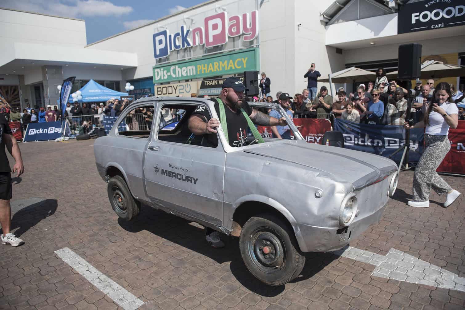 Kelin Mills lifts a 350kg car and walks across the parking lot in the Strongman Challenge