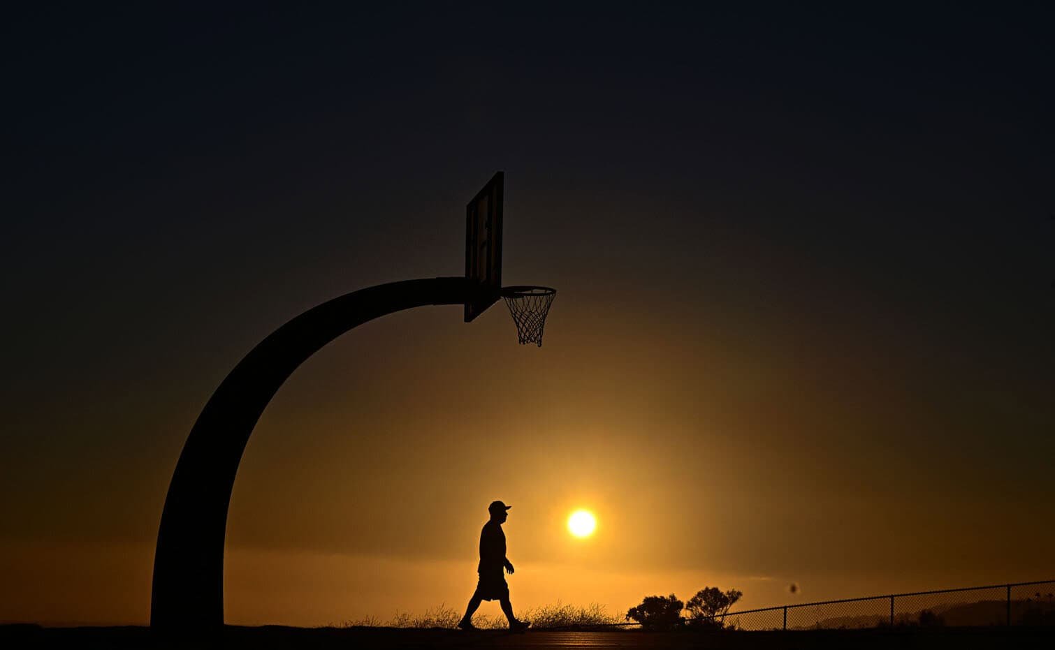 A man walks beneath a basketball hoop