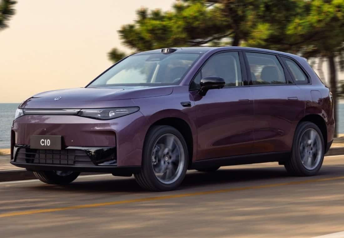 Sustainable electric vehicle in motion on a scenic coastal road in South Africa.