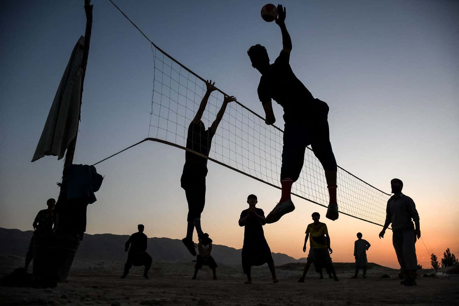 Afghan men play volleyball