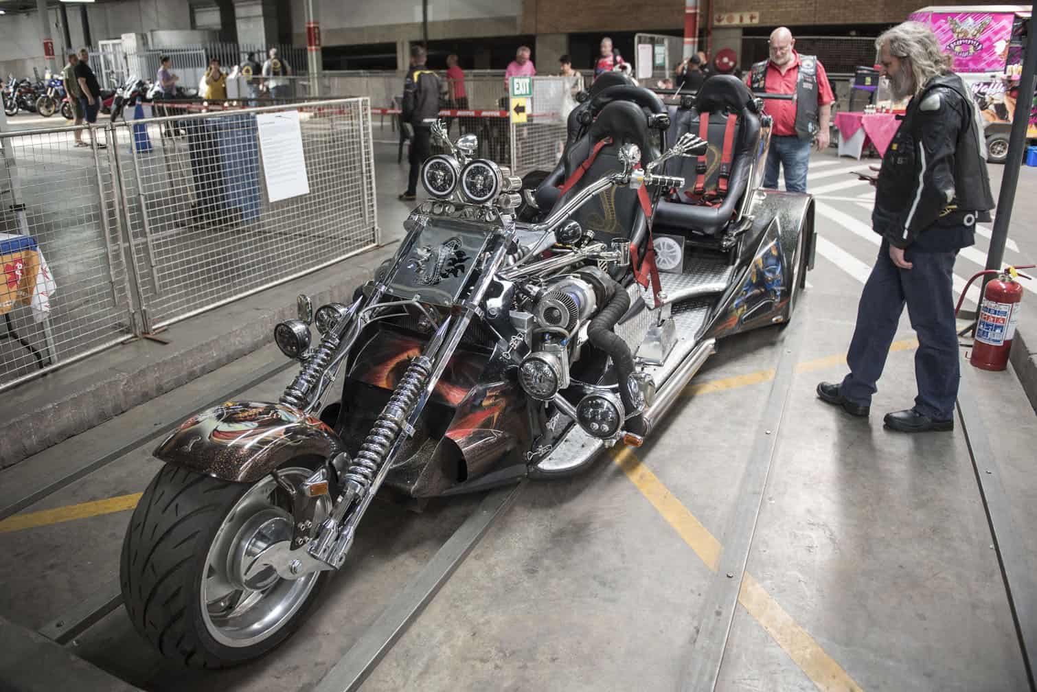 A biker examines an unusual bike