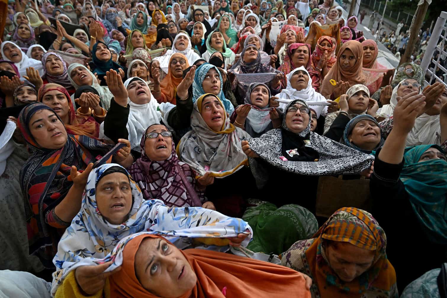 Muslim devotees react as a priest displays a relic