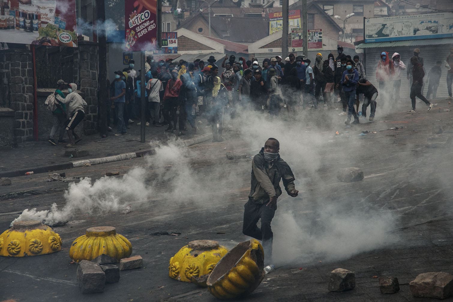 A protester throws a stone towards security forces