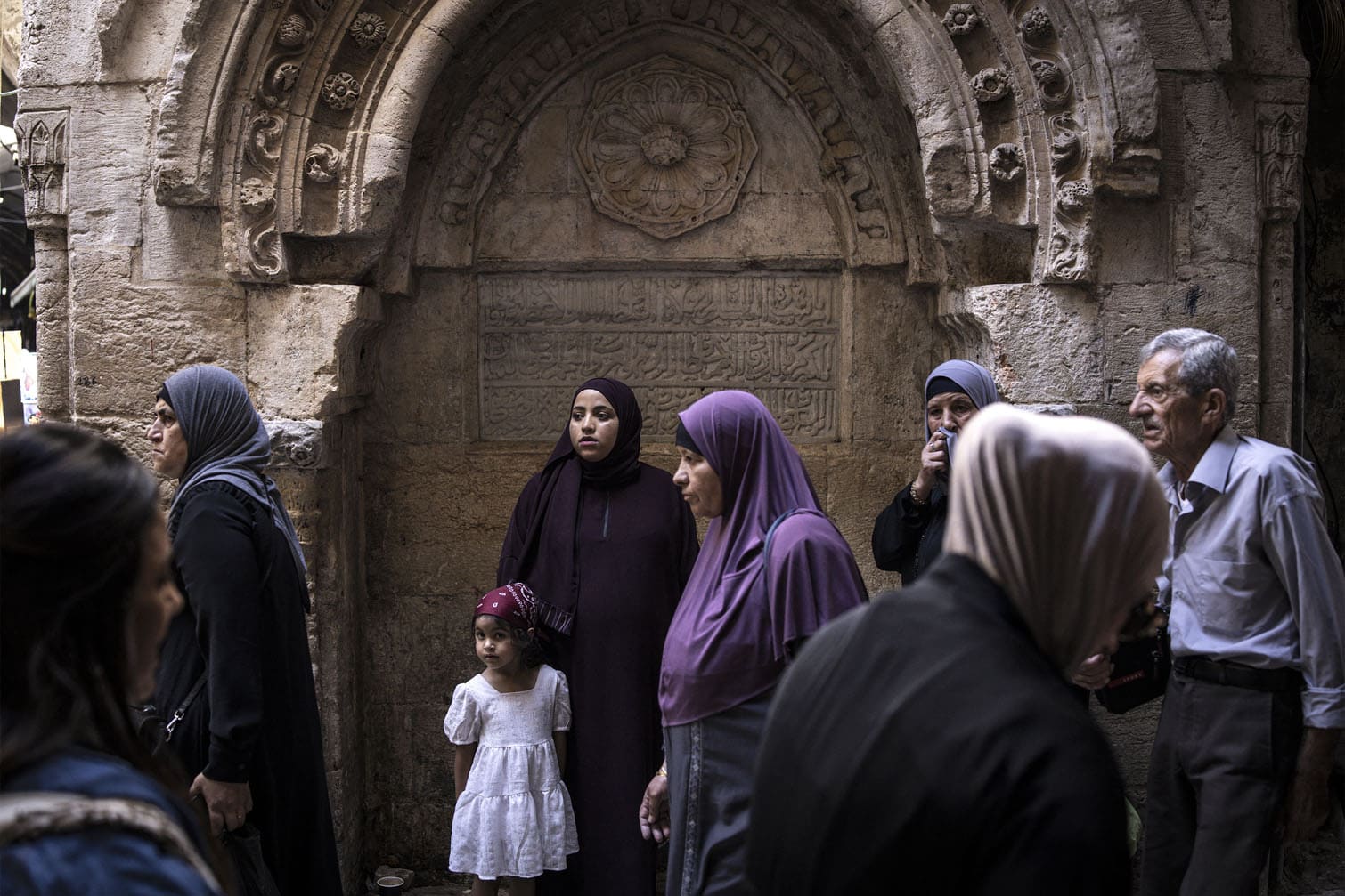 Palestinian families walk through an alley