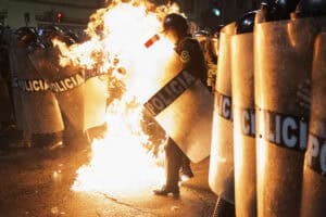 A riot police officer is hit by a Molotov cocktail