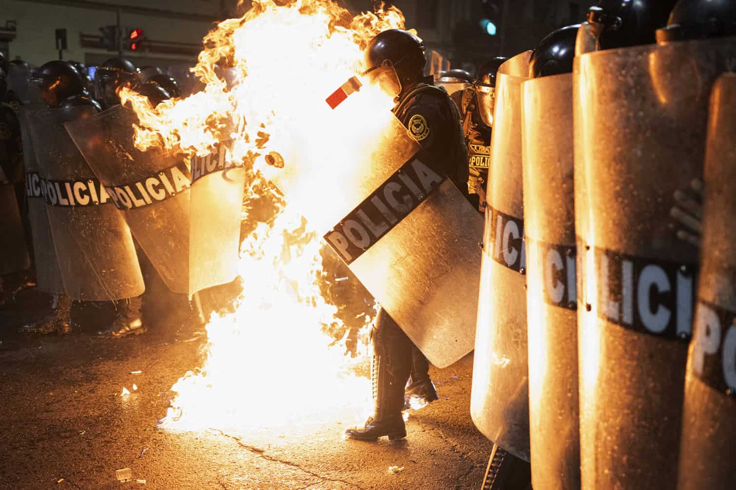 A riot police officer is hit by a Molotov cocktail