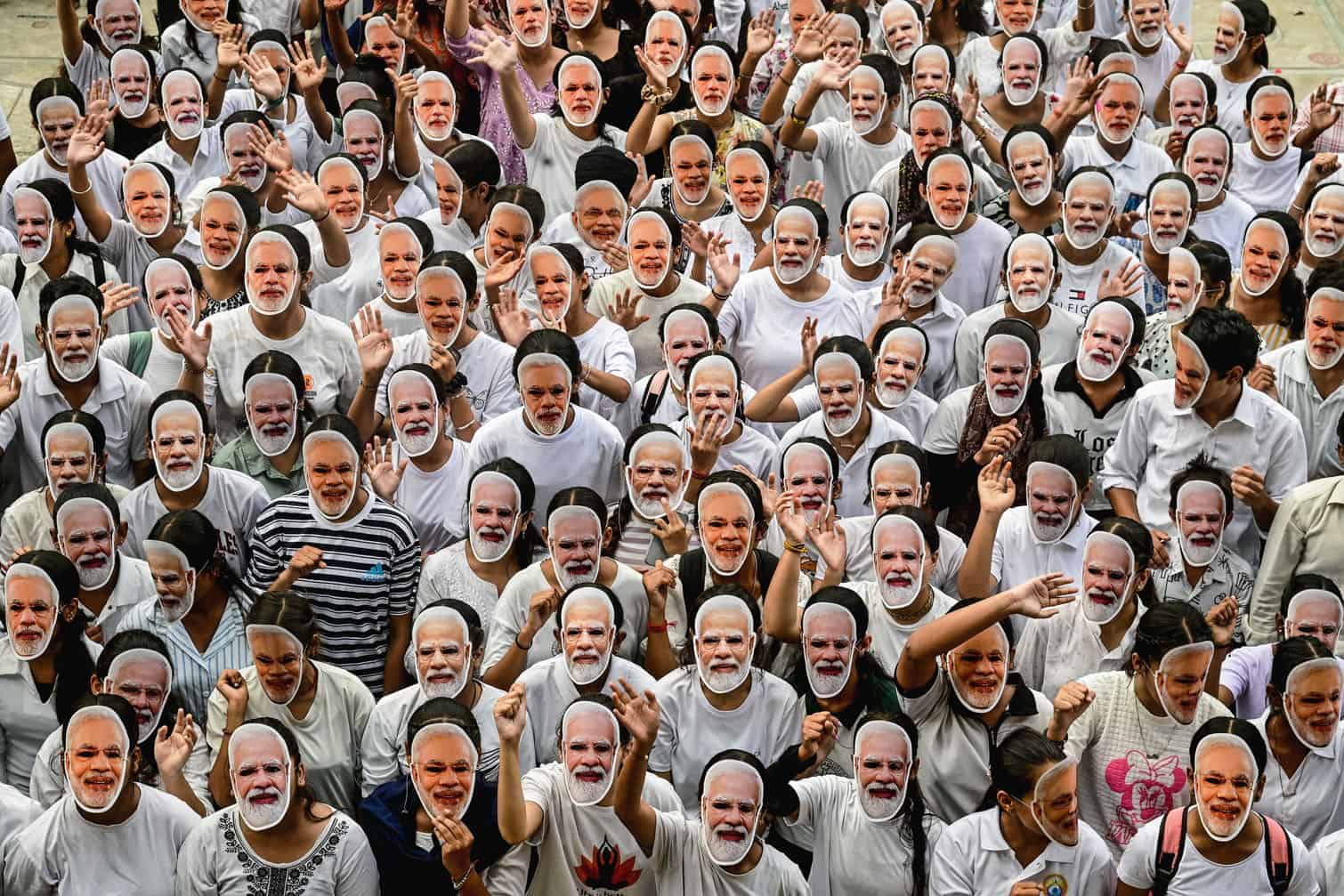 Students wear masks of India's Prime Minister Narendra Modi