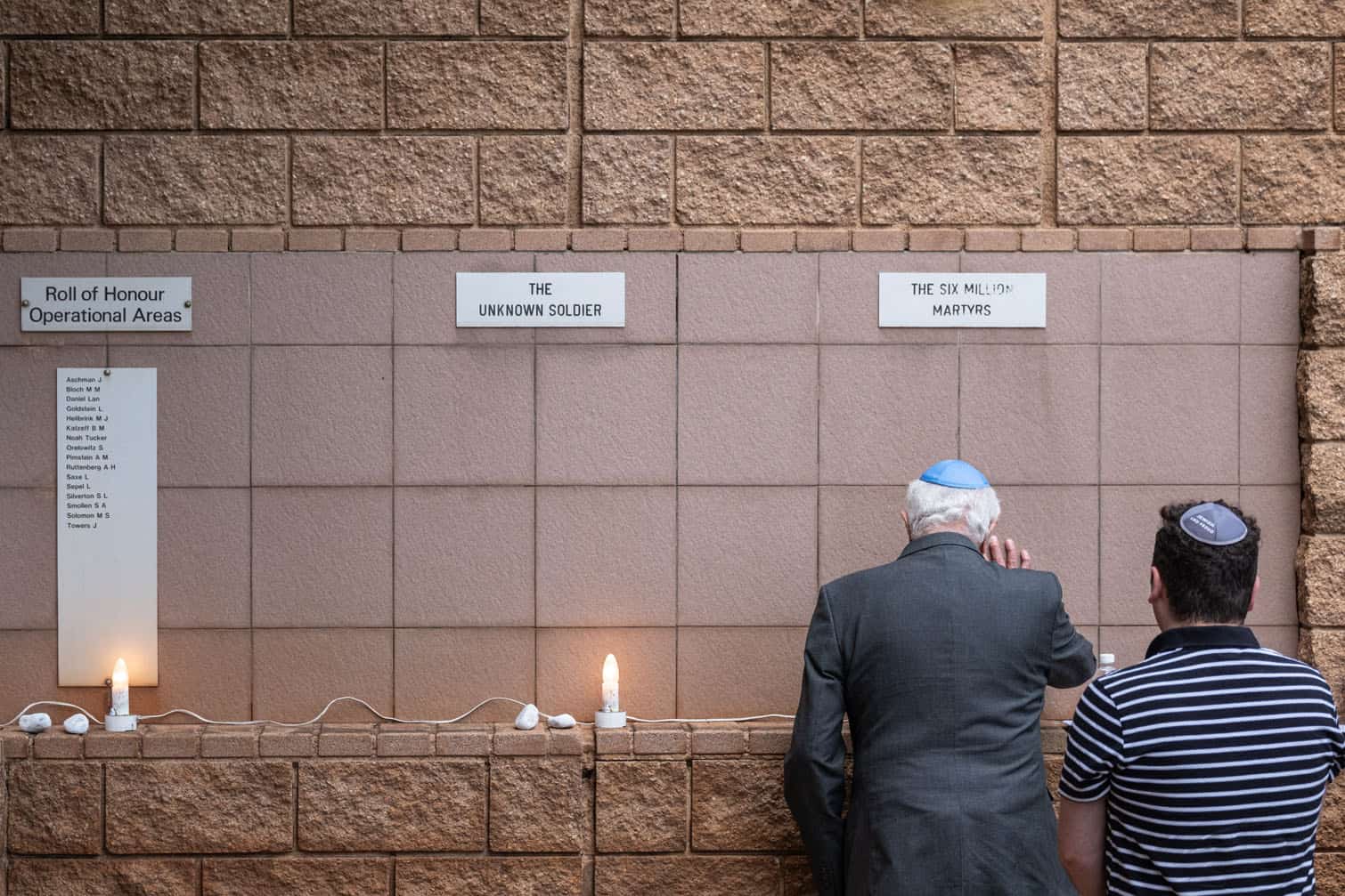 A veteran places his hand on a memorial wall
