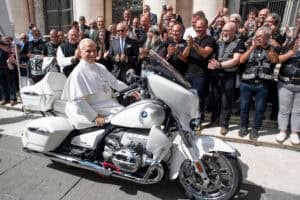 Pope Leo XIV posing on a a white BMW R18 motorbike