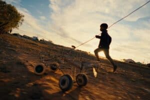 Child playing with a wire car