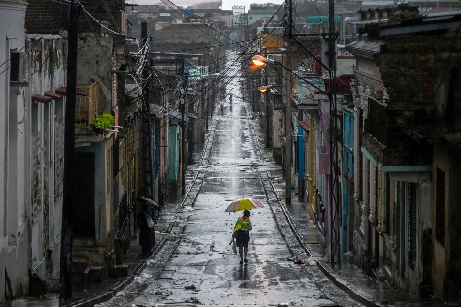 A woman walks in a street before Hurricane Melissa hits