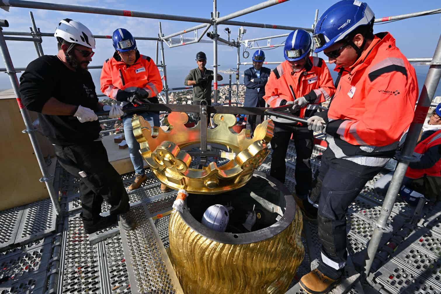 Technicians reinstall the crown of the Virgin Mari