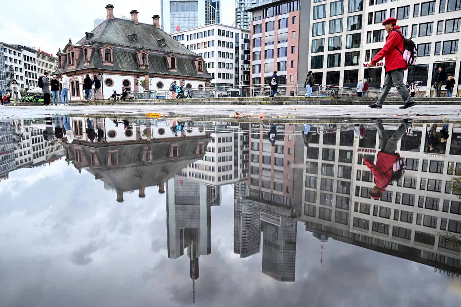 A woman is reflected in a puddle