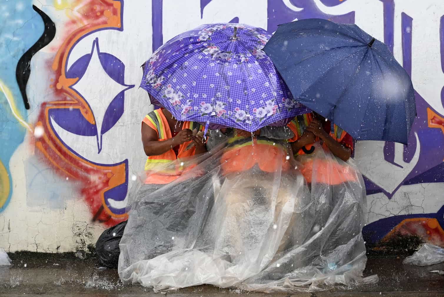 People in the street protect themselves with umbrellas
