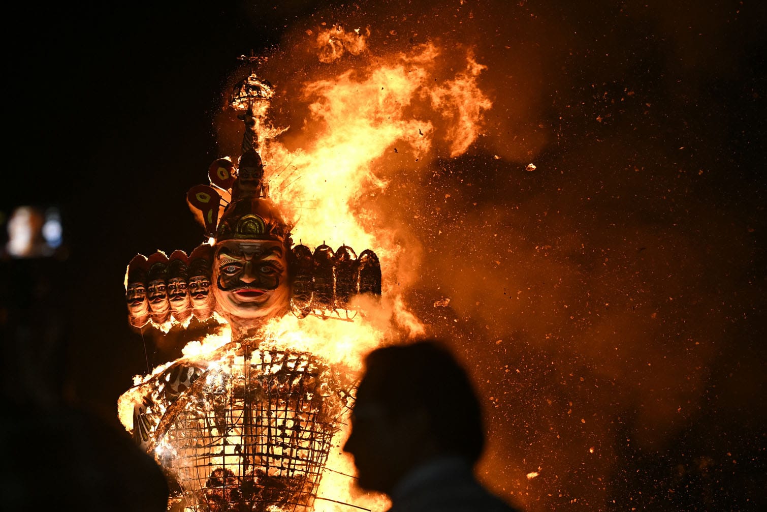 A man watches as an effigy of the Hindu demon king Ravana burns