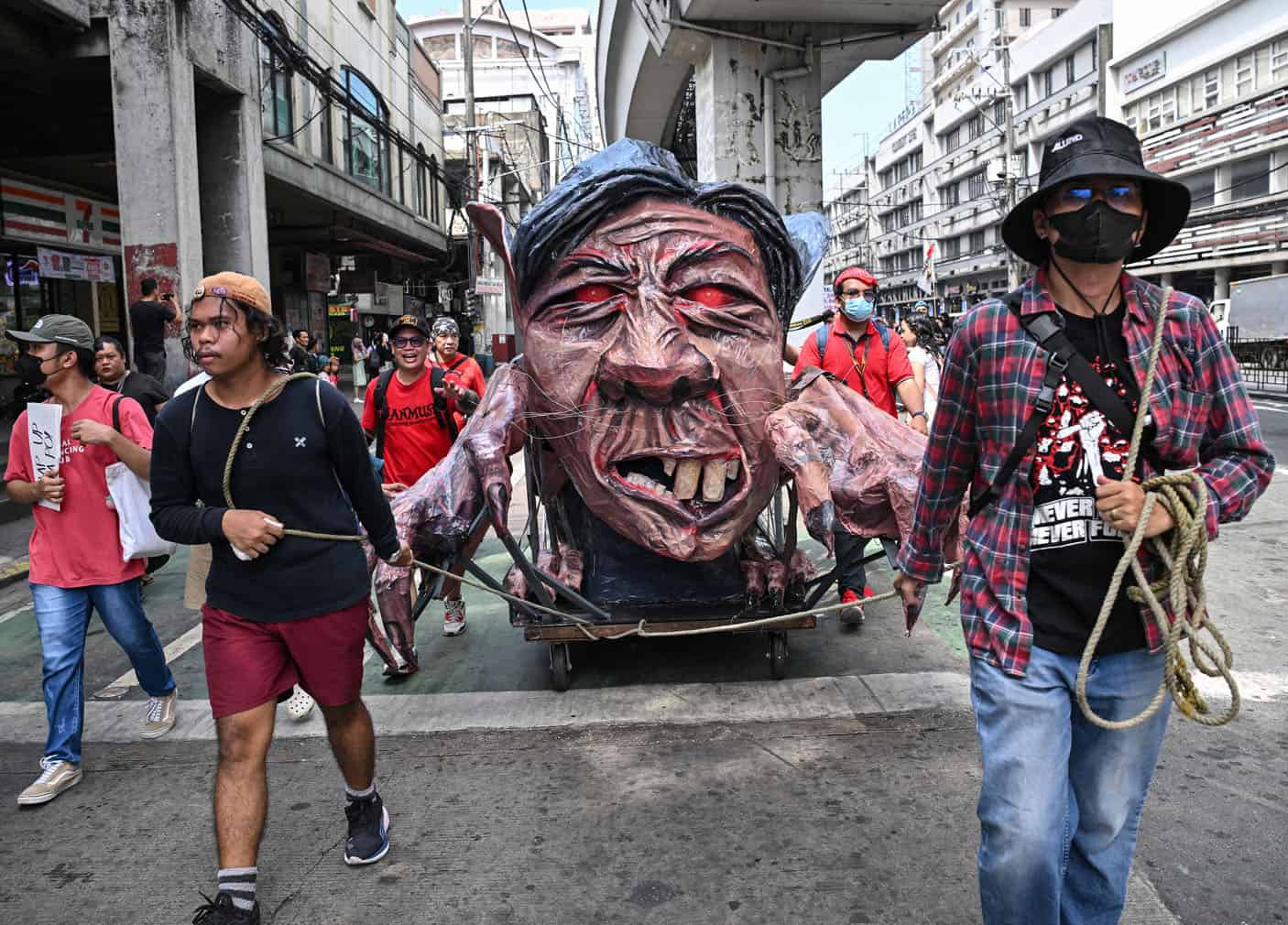 Protesters pull a cart with an effigy