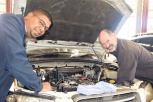 Experienced mechanics inspecting a car engine during maintenance or repair. Car service and auto repair in South Africa.