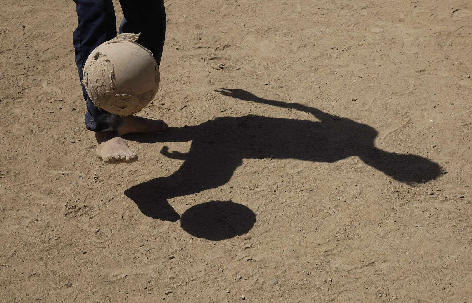 Youths play on a field amid Yemen's conflict