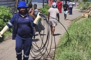 A municipal employee carry the cables that were removed from the Informal settlement.