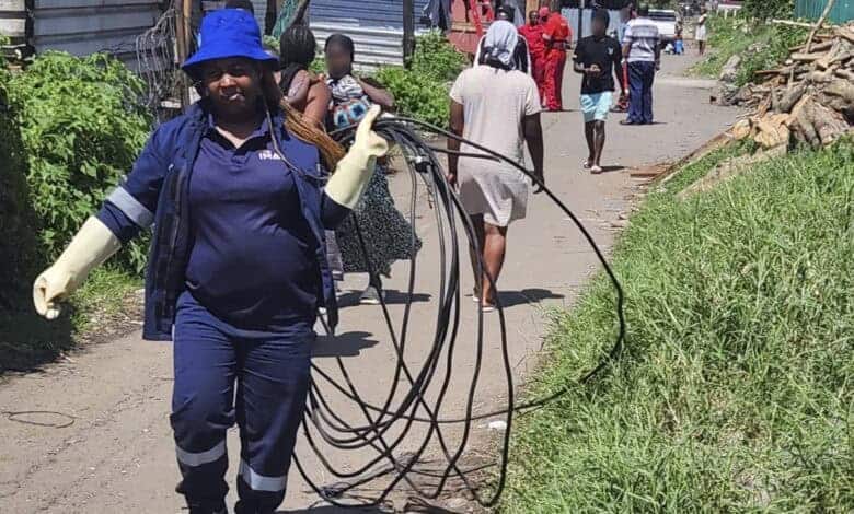A municipal employee carry the cables that were removed from the Informal settlement.