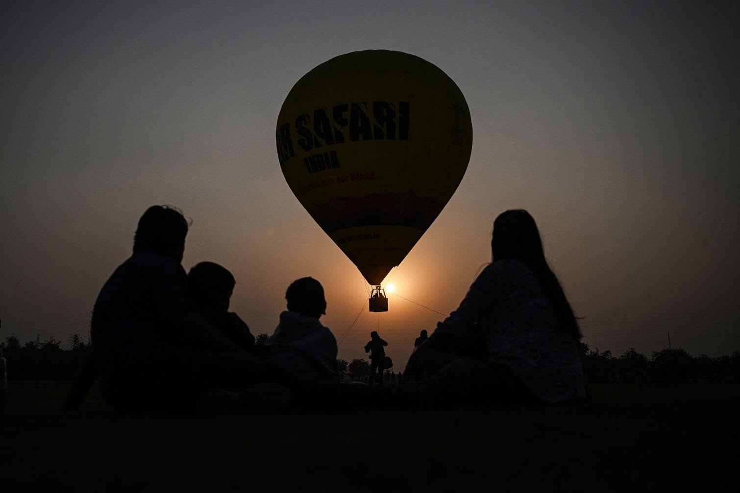 People watch as a hot air balloon lifts off
