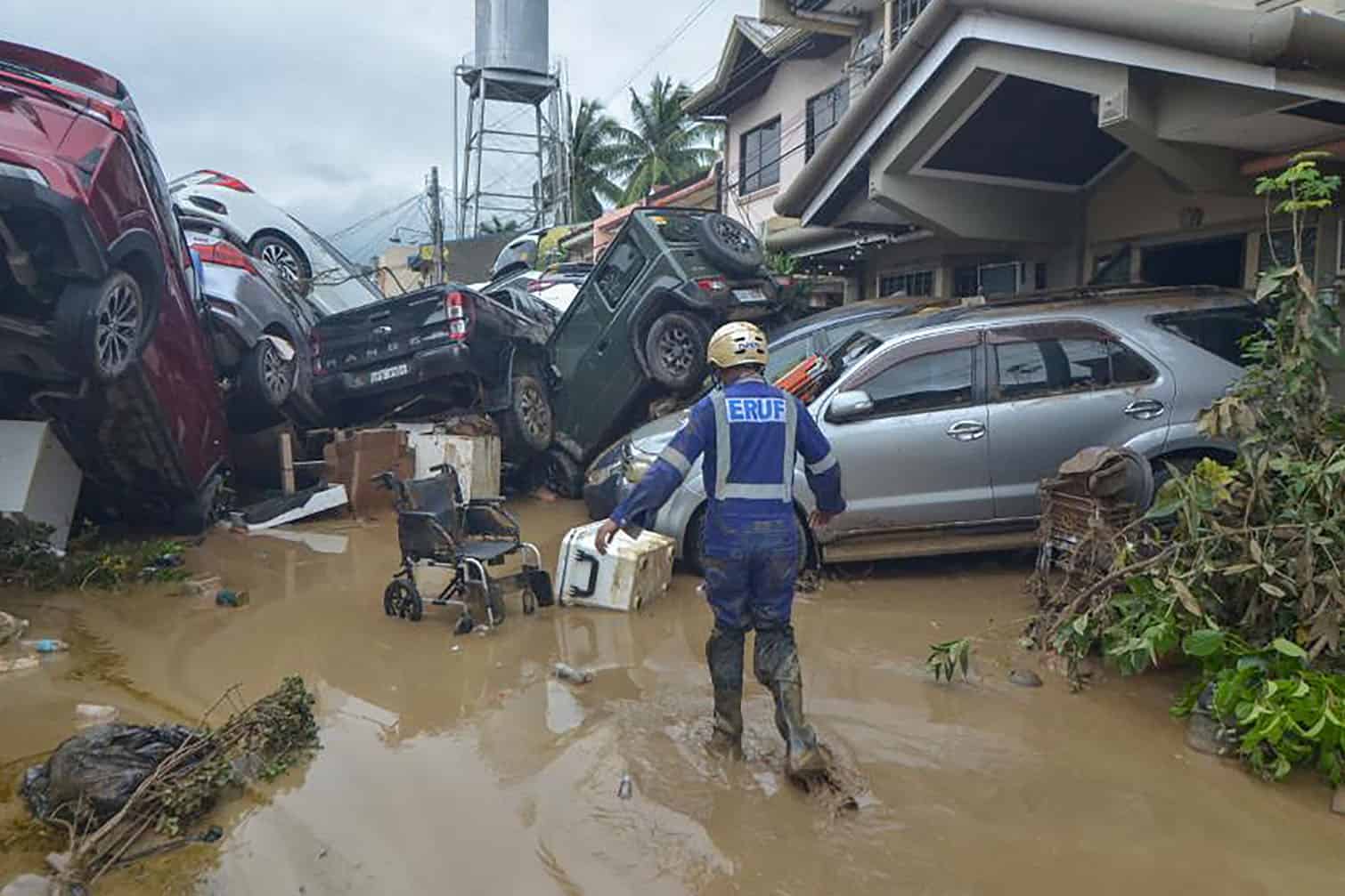 A rescuer walks past piled up cars