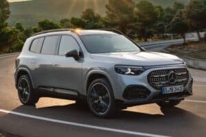 Luxury SUV on open road in scenic countryside.