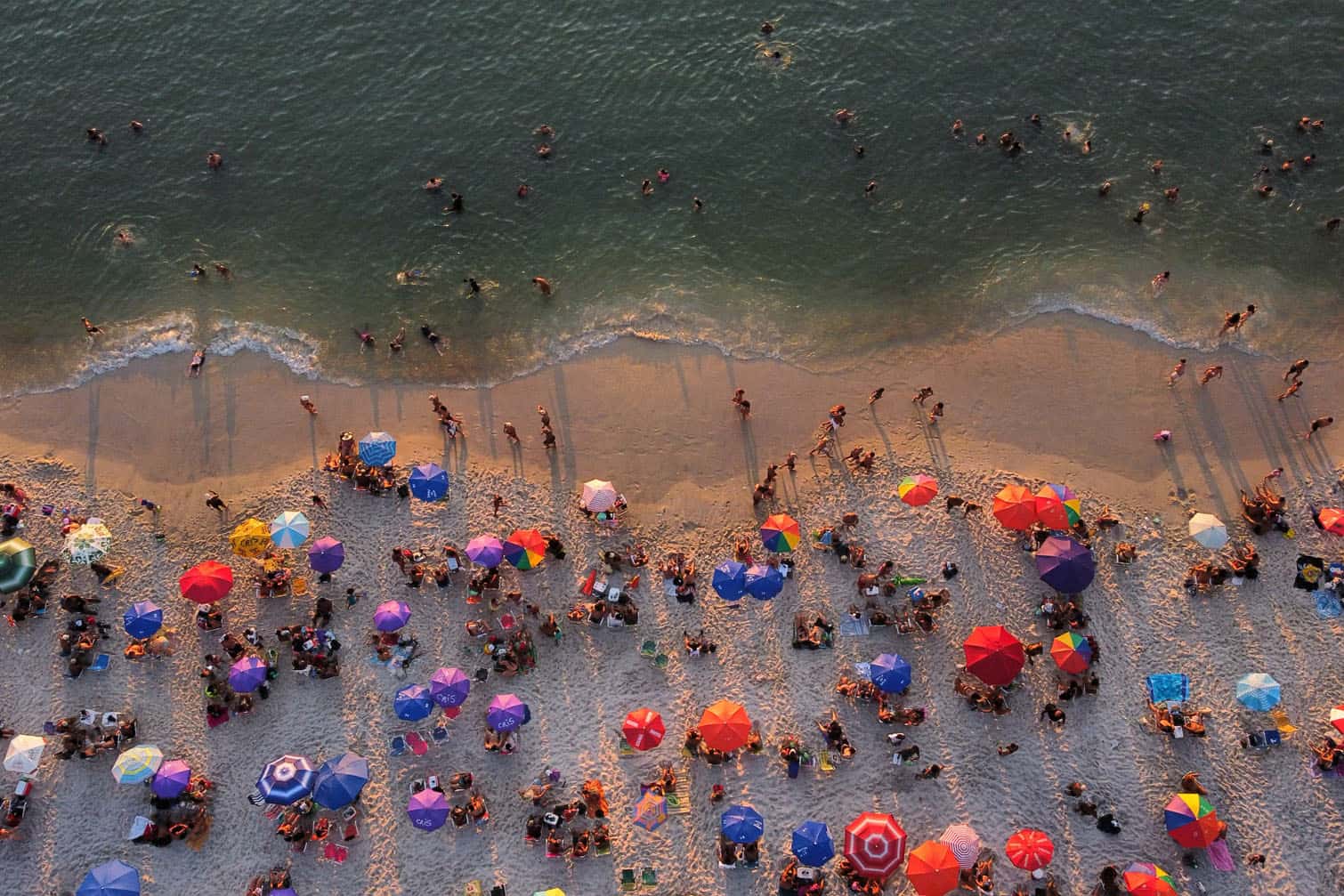 An aerial view shows people enjoying Barra de Guaratiba beach