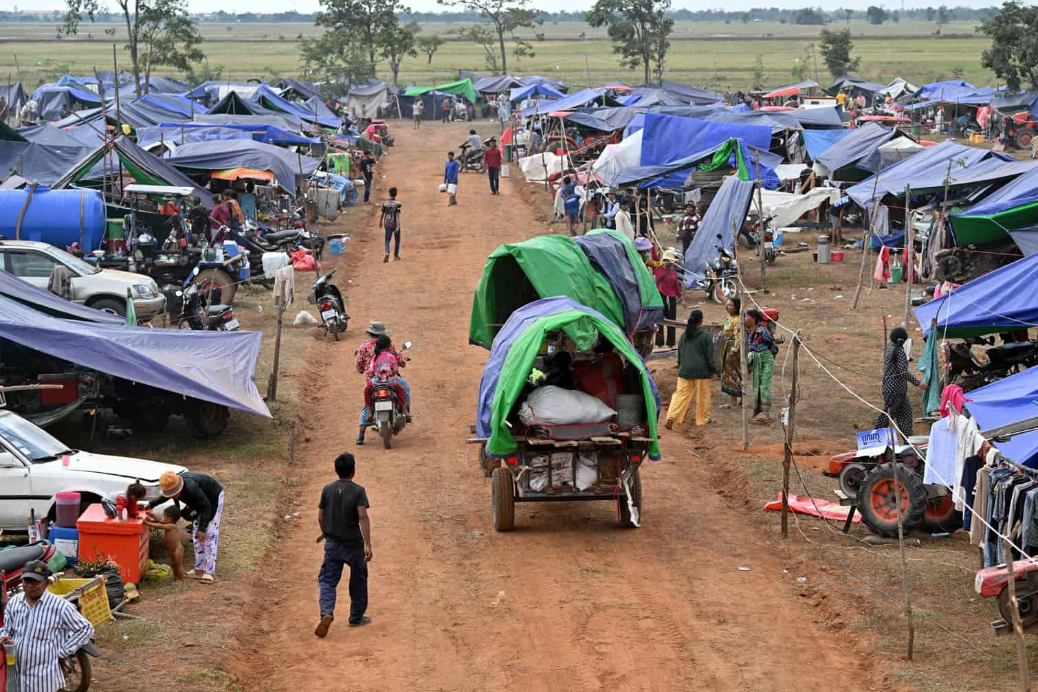 Displaced people arrive at a temporary camp