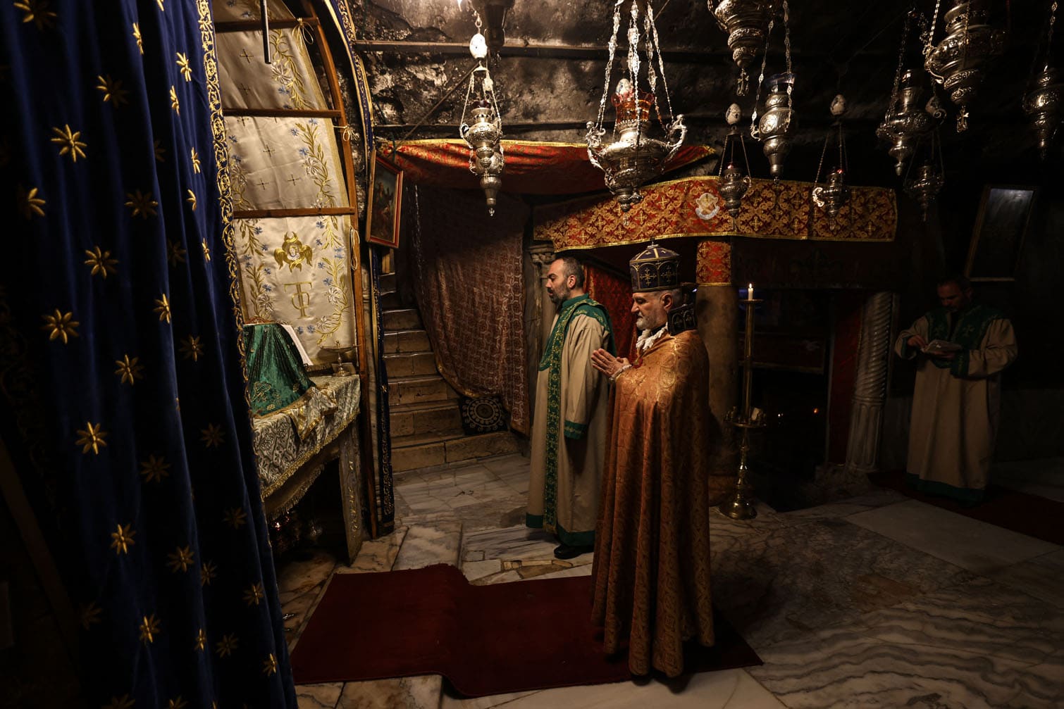 Members of the clergy pray inside the Grotto