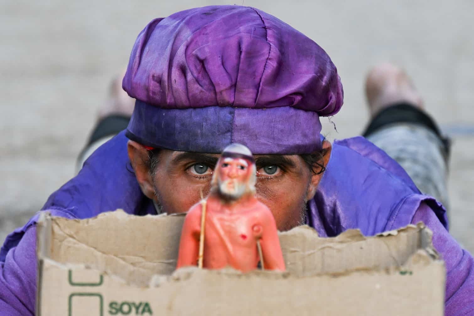 A man looks from behind an image of Saint Lazarus