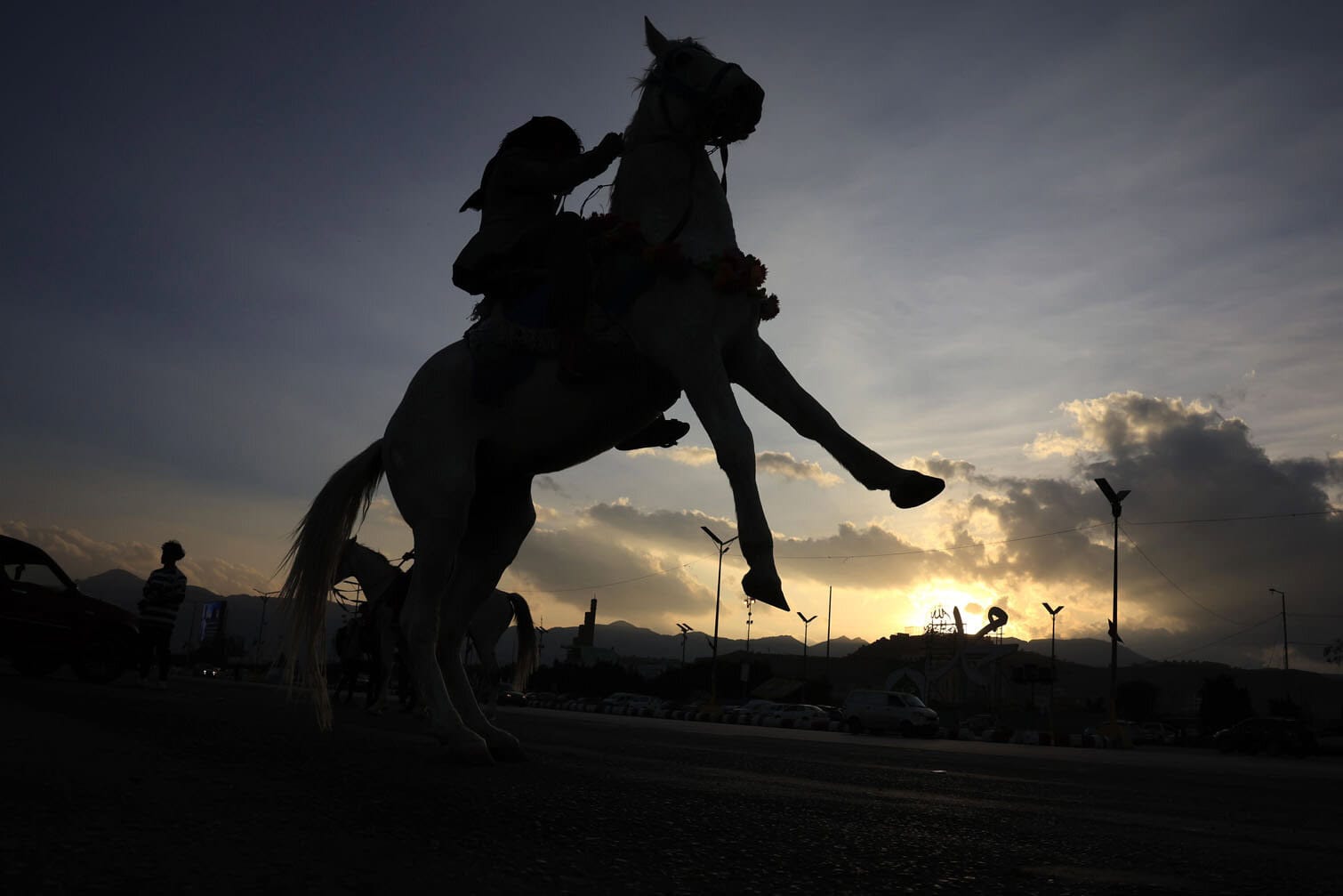Yemenis on horseback ride at dusk in Sana'a