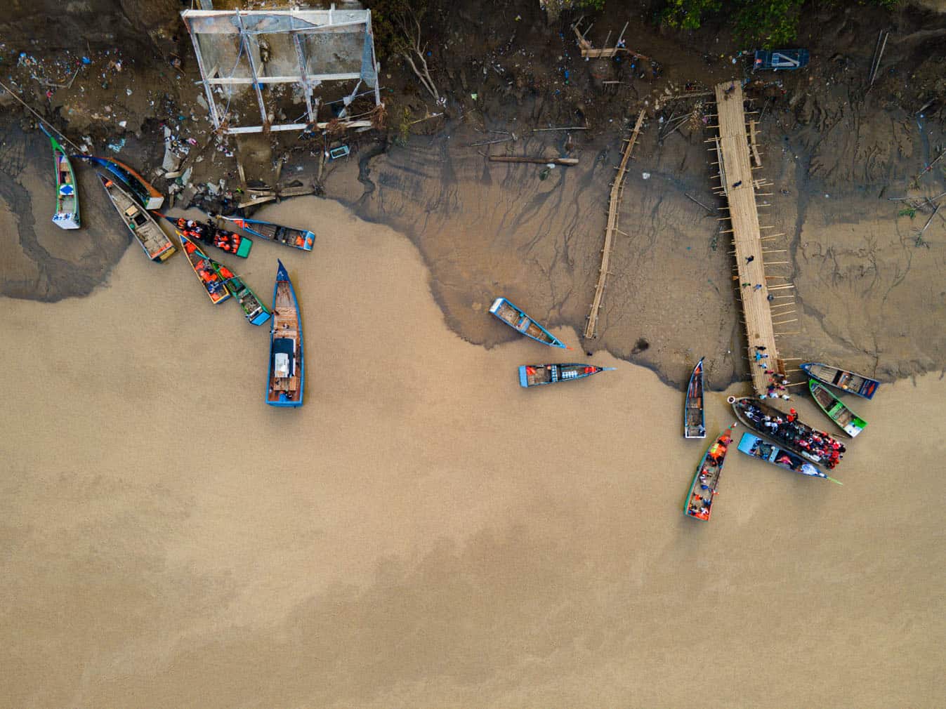 An aerial view shows passengers boarding boats to cross the Peusangan river