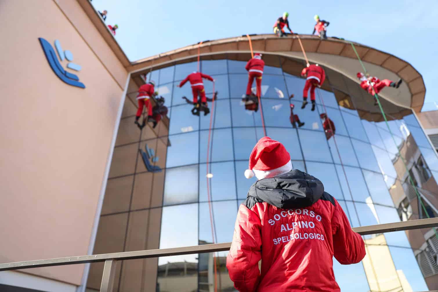 Italian National Alpine and Speleological Rescue Corps members greet hospitalized children